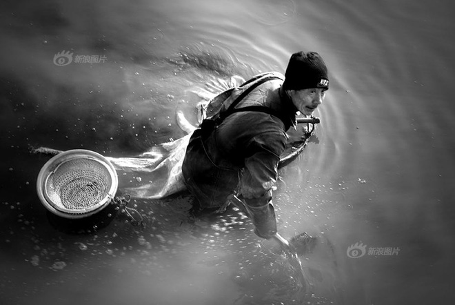Trong ảnh là một người dân đang cố bắt cá cho bữa cơm chiều ở một con kênh ô nhiễm, nồng nặc mùi hôi thối tại Liêu Ninh - một thành phố công nghiệp nặng tương đối lớn tại Trung Quốc.