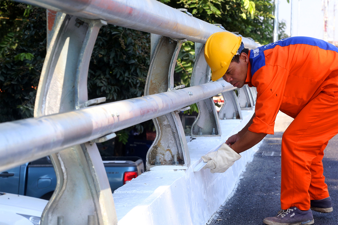 Anh Trần Trung Thành, nhân viên Công ty công trình Giao Thông Hà Nội, đang sơn thêm vạch đỏ hai bên thành cầu. Dự kiến cầu vượt này sẽ được khánh thành vào ngày 7/10.