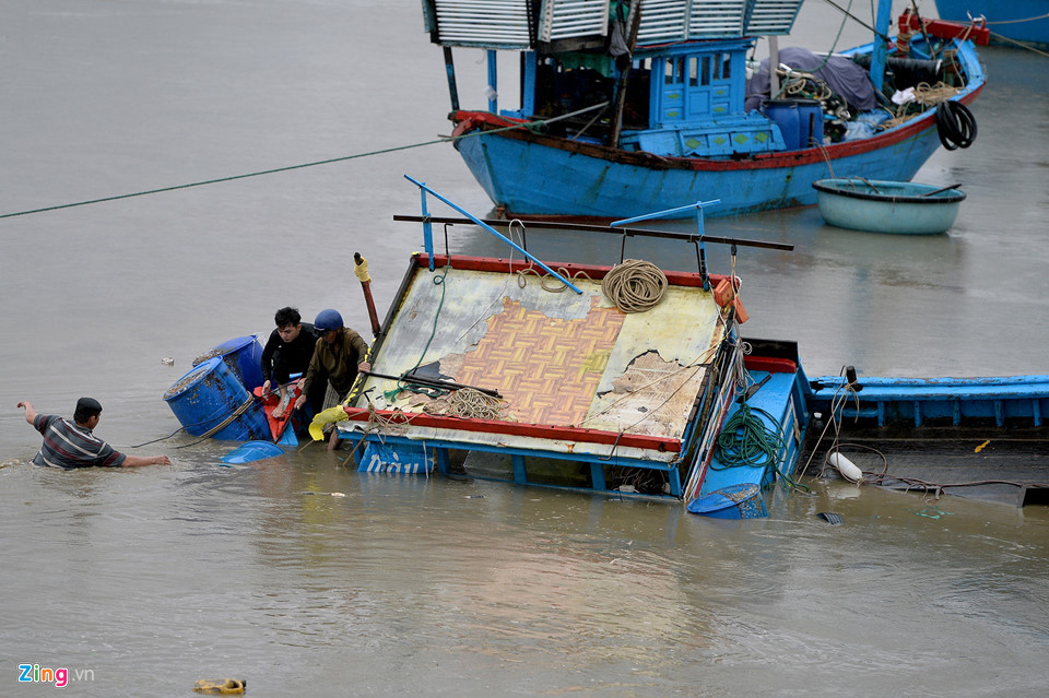 Ngư dân vớt vát đồ đạc trên chiếc tàu đánh cá bị chìm ngay tại bến trên sông Hà Ra (Nha Trang, Khánh Hòa). Như vậy, hiện đã có 11 người chết do bão số 12 - Damrey.