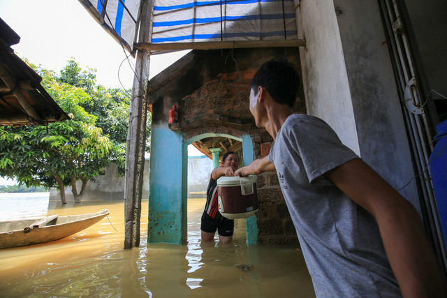Gia đình anh Nguyễn Văn Mạnh chuẩn bị bữa cơm trưa bất chấp nước vẫn ngập nửa nhà.