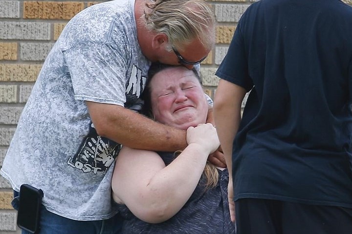 Một phụ nữ khóc lóc đau khổ phía ngoài khu tập gym, nơi các bậc phụ huynh đợi để gặp lại con mình sau vụ xả súng.