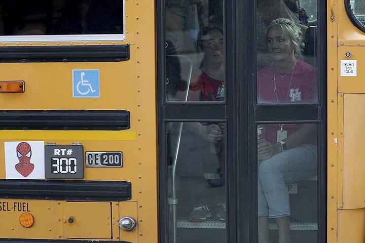 Vẻ bàng hoàng trên gương mặt các nhân viên nhà trường ngồi trong một xe buýt để được đưa sang một trường khác sau vụ xả súng.