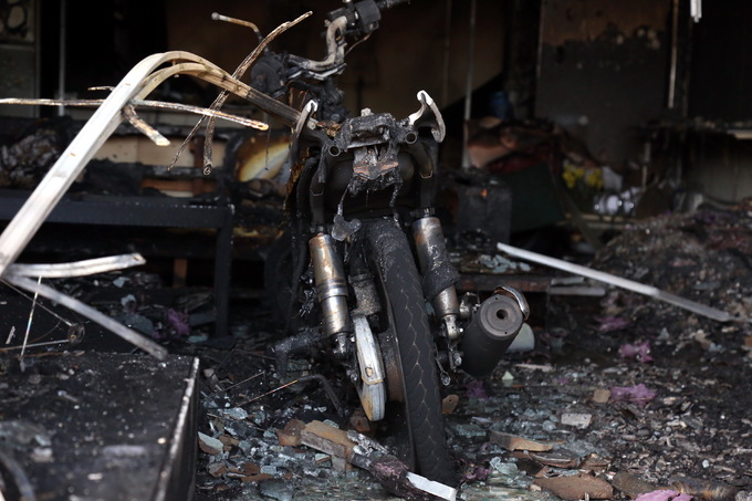 Một chiếc xe máy để bên trong một cửa hàng khác cũng bị cháy trơ khung.
