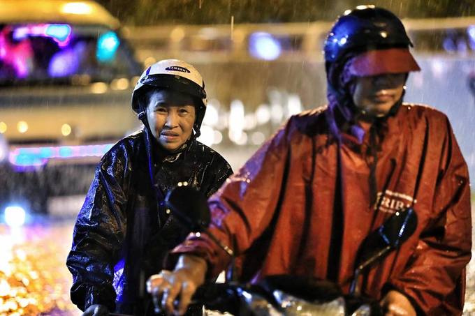 Bà Hoàng Thị Khuyến cho biết phải cùng con đẩy bộ xe nhiều km trên đường ngập. "Hôm nay mưa bão cả ngày, biết đường sẽ ngập nhưng không ngờ kinh khủng thế này.", bà nói.