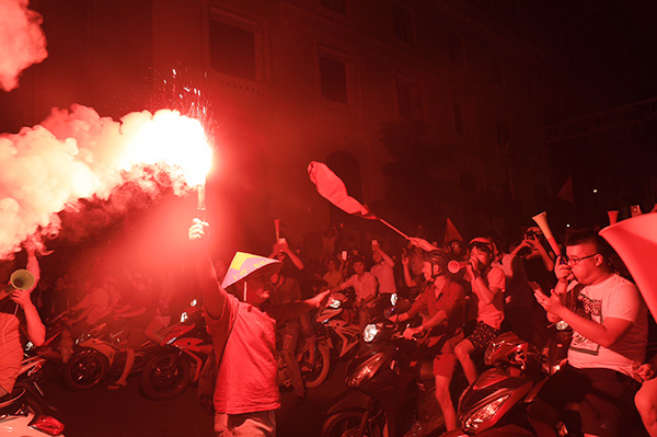 Một fan Sài Gòn đốt pháo sáng trong tiếng reo hò phấn khích của mọi người xung quanh.