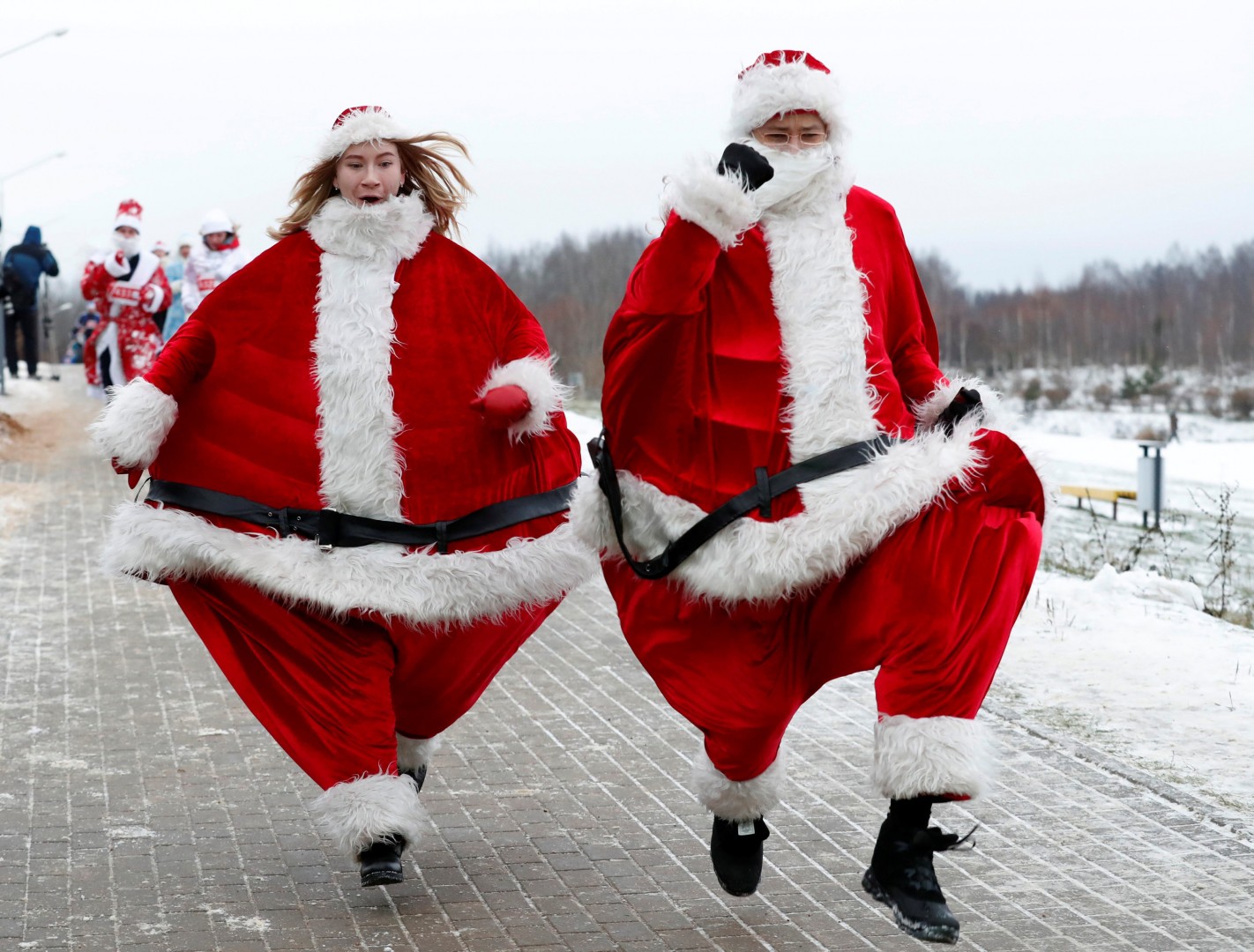 Cặp đôi mặc trang phục của ông già Noel đang tham gia cuộc thi chạy Santa Run ở Minsk, Belarus. (Ảnh: Reuters)