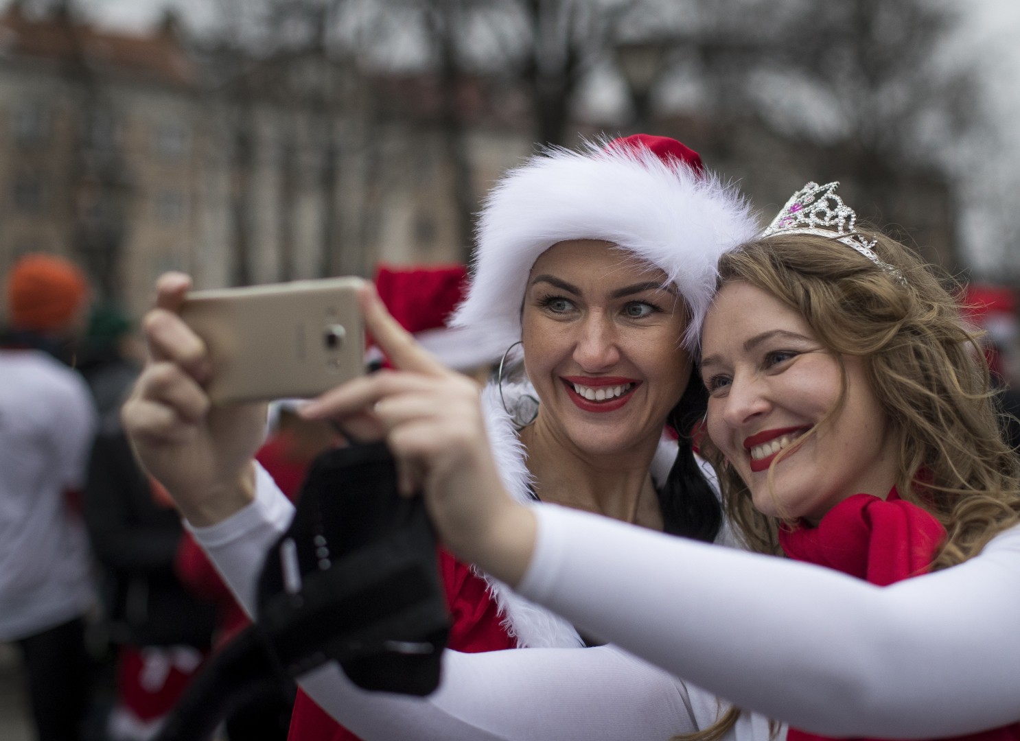2 cô gái rạng rỡ trong bộ trang phục đỏ - trắng mừng Giáng sinh tại Vilinus, Lithuania. (Ảnh: AP)