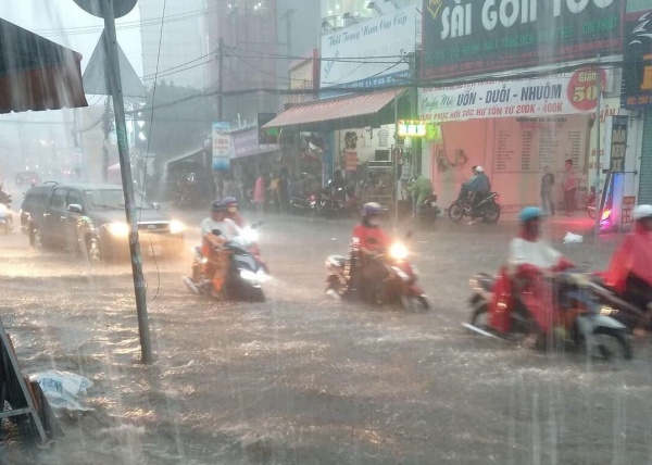 Người và xe bơi trong biển nước tại Sài Gòn, sau cơn mưa nước đổ như thác