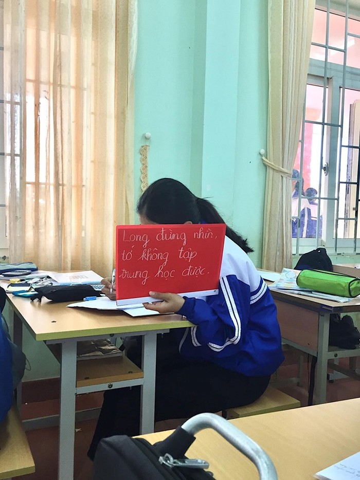 Chuyện tình học đường siêu dễ thương qua tấm bảng “Long đừng nhìn, tớ không tập trung học được” trên tay nữ sinh
